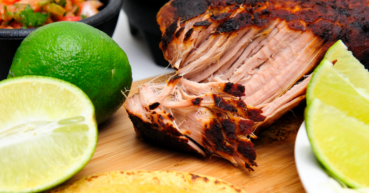 shredding pork on a wooden cutting board